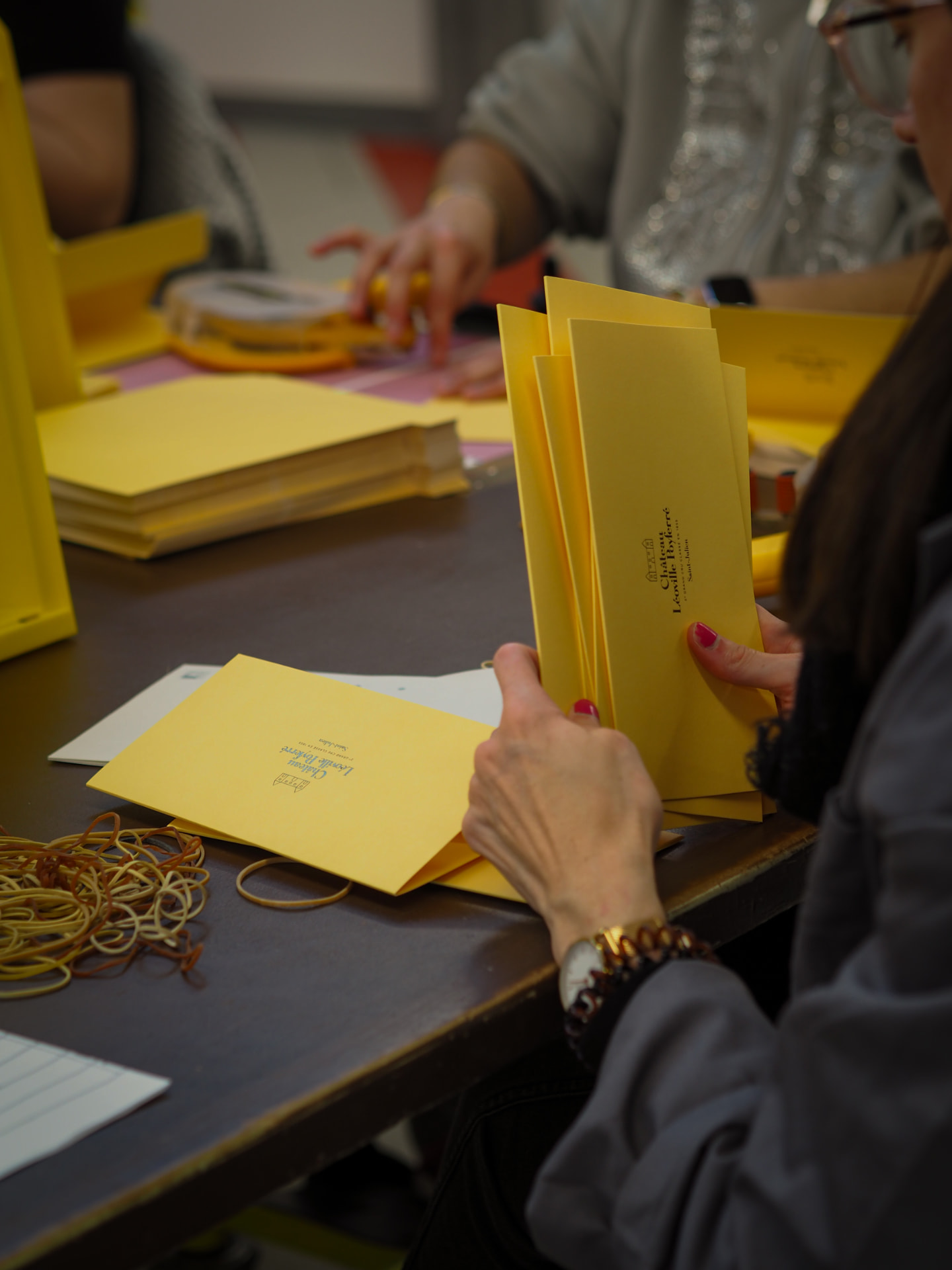 Mise sous pli et préparation de pochettes jaunes à l'atelier