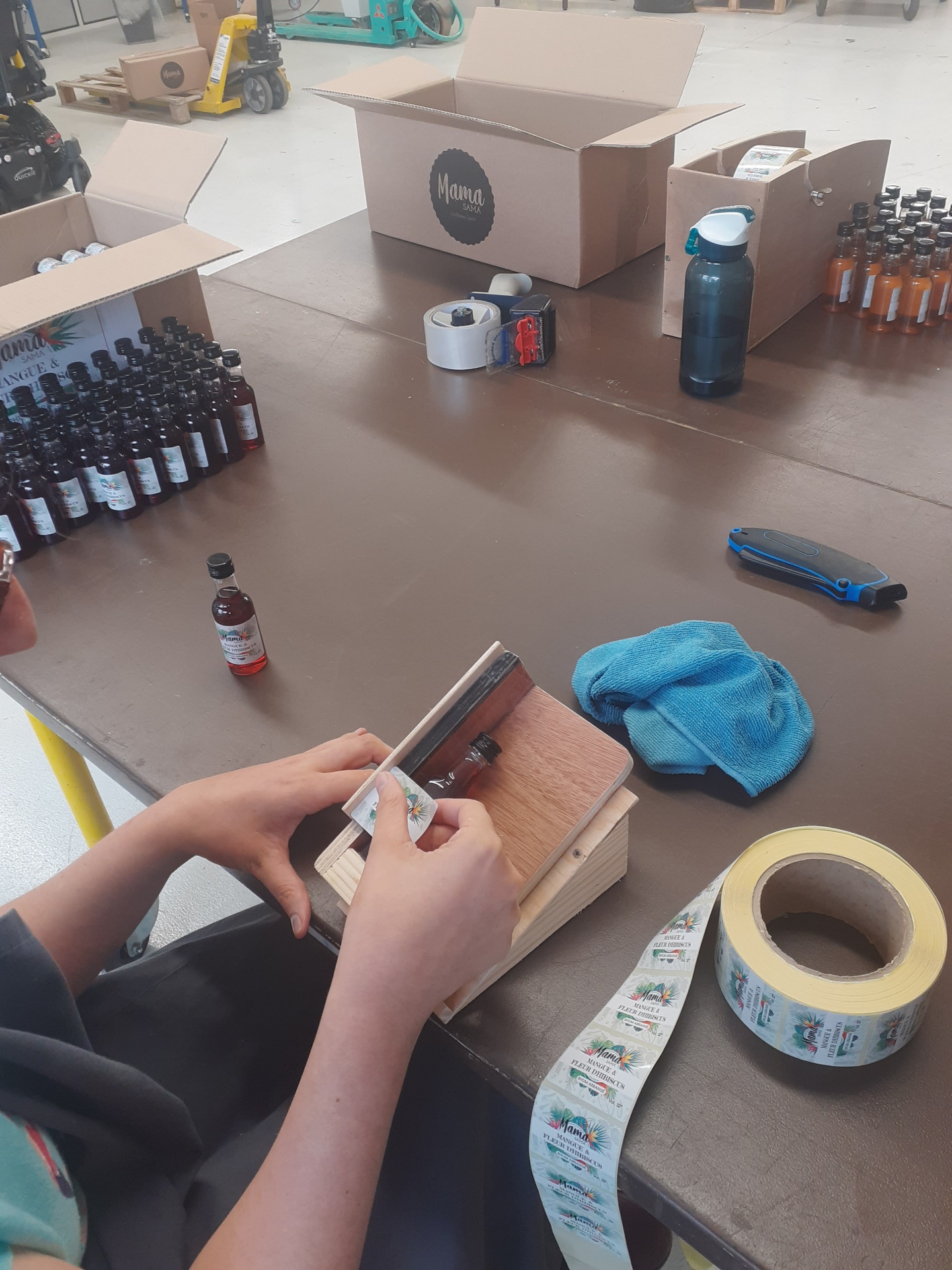 Étiquetage de flacons à l'atelier conditionnement